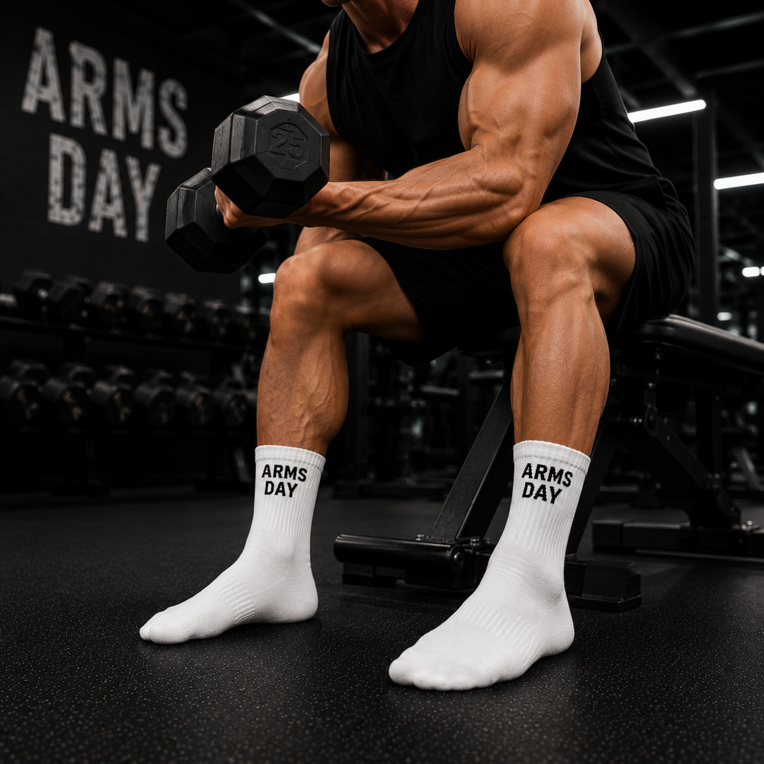Person lifting weights with 'Arms Day' socks on, gym setting